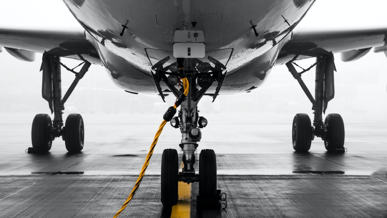 Airplane with yellow coated cable inserted near landing gear